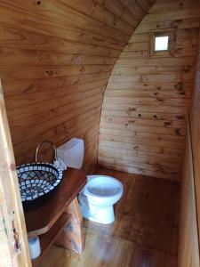 un bagno con servizi igienici in una cabina di legno di Hostel Chacra La Templanza a El Hoyo
