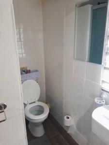 a white bathroom with a toilet and a sink at SHALOM in Margate