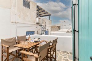 y balcón con mesa y sillas de madera. en The Naxos Loft with view of the Castle, en Naxos Chora