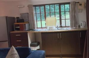 a kitchen with a counter with a sink and a window at Timber Ally Cabin in Umtentweni