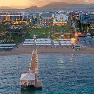 un muelle en el agua junto a una playa con barcos en Dobedan Beach Resort Comfort ''Ex Brand Alva Donna Beach Resort Comfort'', en Side