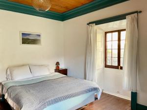 a bedroom with a bed and a window at Casa Via d'Agua in Fajã Grande in Faja Grande