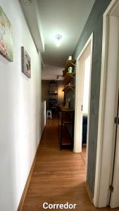 a hallway leading to a room with a wooden floor at Apartamento 2 quartos completo com garagem in Juiz de Fora