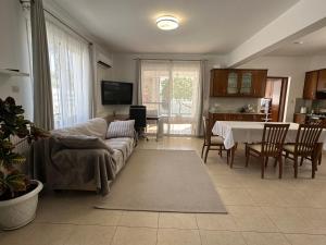 een woonkamer met een bank en een tafel bij Villa Andy-350 m from the beach in Larnaka