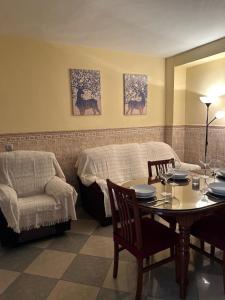 Cette chambre comprend une table, un lit, une table et des chaises. dans l'établissement Casa Ancá Los Abuelos, à Rute