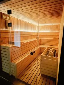 a sauna with wooden walls and a glass door at Old Town Nadmotławie - Sauna & Gym I 10min deptak in Gdańsk