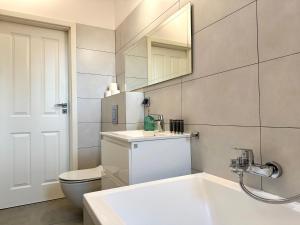 a bathroom with a sink and a toilet and a mirror at Apartament Willow in Gdańsk