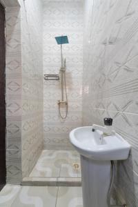 a white bathroom with a sink and a shower at Home from Home Lekki - 2 Bedroom Idado Lekki in Lagos