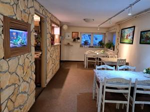 a room with a stone wall and a table and chairs at Alcorso Pension in Banská Bystrica