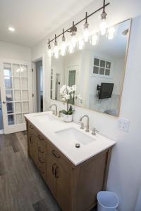 baño con lavabo y espejo grande en Little Chi Cottages, en Noblesville