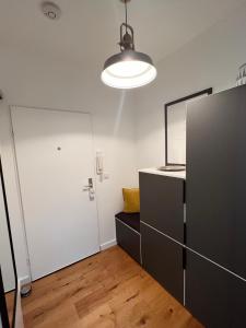 um quarto com um frigorífico preto e uma porta branca em Charmantes Studio Maschsee und Messe Nähe em Hanôver