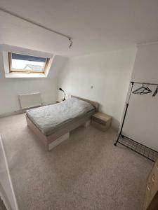 Schlafzimmer mit einem Bett und einem Fenster in der Unterkunft Joli appartement 2 chambres face gare in Forbach
