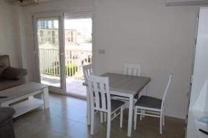 a dining room with a table and chairs and a balcony at Baleares III Apartamento a 100 metros de la arena in Los Mártires +18 photos