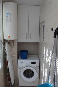 a washing machine in a kitchen with a white cabinet at Baleares III Apartamento a 100 metros de la arena in Los Mártires