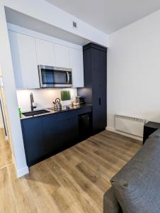 a kitchen with black cabinets and a counter top at LE LOFT BLEU - Centre-Ville de Québec in Quebec City