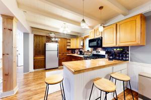 uma cozinha com armários de madeira e um frigorífico branco em Summit House em Windsor