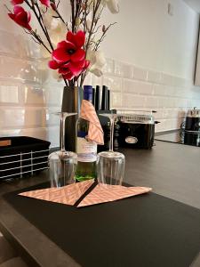 un comptoir avec deux verres à vin et un vase avec des fleurs dans l'établissement Charmantes Studio Maschsee und Messe Nähe, à Hanovre