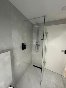 W łazience znajduje się prysznic ze szklanymi drzwiami. w obiekcie Moparts w mieście Oberhausen