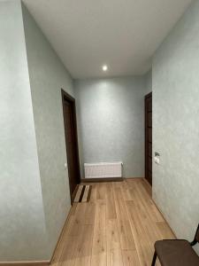een lege kamer met houten vloeren en een witte muur bij Veranda L&G in Koetaisi