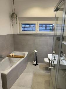ein Badezimmer mit einer Badewanne, einem WC und einem Waschbecken in der Unterkunft Comfort Apartment in Lörrach