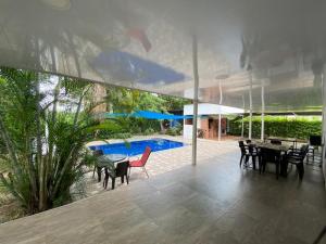 un patio con mesa, sillas y piscina en Casa Quinta Murcia, en Carmen de Apicalá
