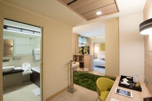 Cette chambre comprend un bureau et une salle de bains pourvue d'un lavabo. dans l'établissement AS Hotel Limbiate Fiera, à Limbiate
