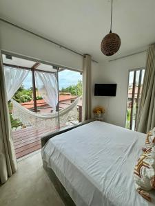 a bedroom with a large bed and a large window at LA RESERVE VILLAS BEIJA-FLOR e IPANEMA in Pipa