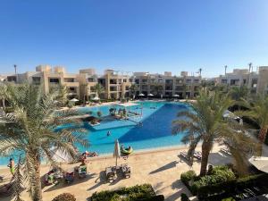 a large swimming pool with palm trees and buildings at El Gouna Mangroovy 2Bd - M10 in El Gouna