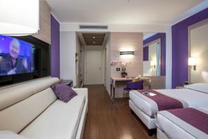 a hotel room with two beds and a flat screen tv at AS Hotel Limbiate Fiera in Limbiate