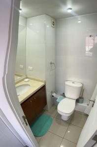 a bathroom with a toilet and a sink and a mirror at Departamento central viña del mar in Viña del Mar