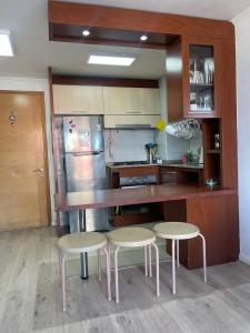 a kitchen with a counter and two stools in it at Departamento central viña del mar in Viña del Mar