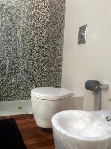 uma casa de banho com um WC branco e um chuveiro em L'Incantesimo em Pescara