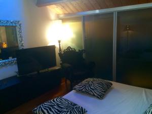 um quarto com uma cama, uma televisão e um candeeiro em L'Incantesimo em Pescara