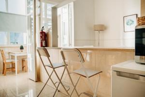 uma cozinha com duas cadeiras em frente a um balcão em Belém Tejo - Jardim em Lisboa