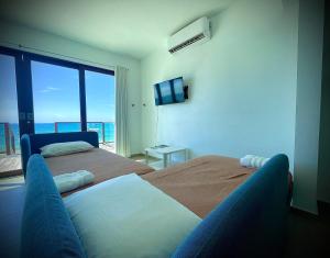a bedroom with two beds and a view of the ocean at 1 Corcega Beachfront Suites in Rincon
