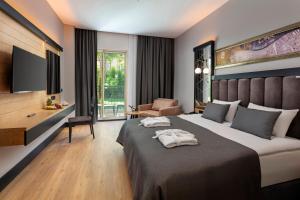 a hotel room with a bed with towels on it at Dobedan Beach Resort Comfort ''Ex Brand Alva Donna Beach Resort Comfort'' in Side