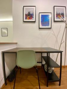 a desk with a green chair in a room with paintings at Gaslini and beaches two steps away in Genova