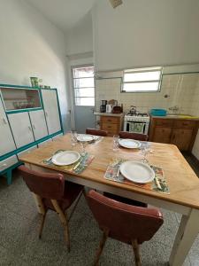 a kitchen with a wooden table with two plates on it at Casa Tradicional del Barrio de la Estación in Tandil