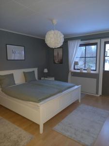 sypialnia z dużym łóżkiem i żyrandolem w obiekcie Smålandshus w mieście Målilla