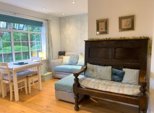 a living room with a bed and a table and a chair at The Lady of the Lake Windermere in Windermere