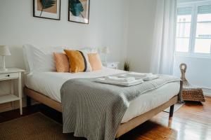 a bedroom with a bed with a blanket on it at Belém Tejo - Jardim in Lisbon