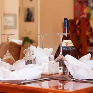 a table with two bottles of wine and glasses at The Farmhouse Inn in Nanyuki