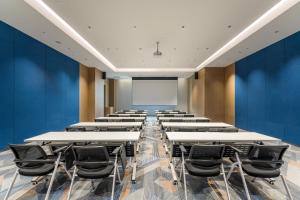a lecture room with tables and chairs and a whiteboard at Holiday Inn Express Heze City Center, an IHG Hotel in Heze