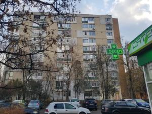 a tall building with cars parked in front of it at Stone Bridge Studio in Iaşi