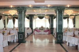 um salão de banquetes com mesas e cadeiras brancas em Argavand Hotel & Restaurant Complex em Argavand