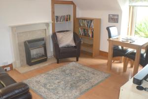 a living room with a chair and a fireplace at Strathallan B&B in Inverness