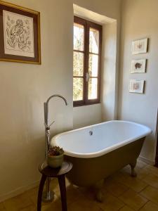 La salle de bains est pourvue d'une baignoire et d'une fenêtre. dans l'établissement Le Mas de Roussa, à Meyrannes