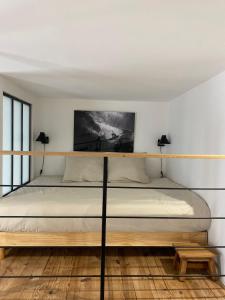 a bed in a white room with two lamps at Athéna in Caen