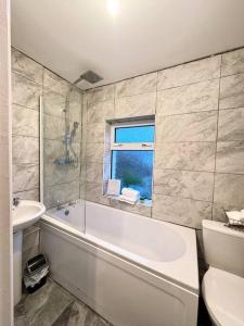 a bathroom with a tub and a sink and a toilet at Flat 71 in Bristol