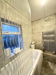 a bathroom with a tub and a window at Flat 71 in Bristol